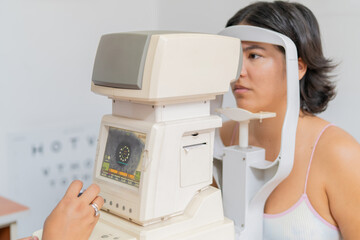 An unrecognizable optometrist examining young woman's eye