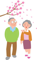 桜を見ながら散歩する高齢夫婦
