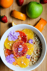 Oatmeal or oat porridge with banana citrus fruits fresh orange and blood oranges and almond 
