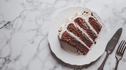   A cake sits atop a white plate, accompanied by a knife, fork, and marble surface