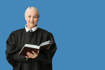 Mature female judge with book on blue background