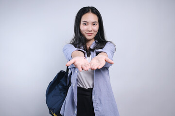 Young Asian Female College Student Presenting Hand To Front Showing Product For Advertisement Isolated On White Background