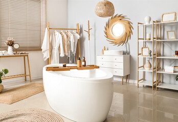 Interior of bathroom with golden mirror, sink and bathtub