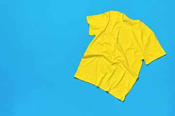A wrinkled yellow T-shirt on a blue background.