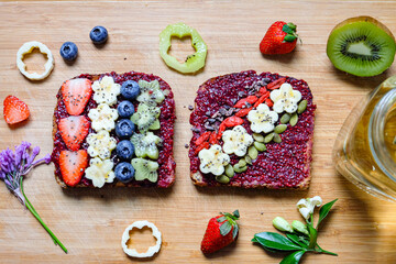 Homemade strawberry and raspberry chia jam toast  with banana kiwi blueberry goji berry and pumpkin seeds  