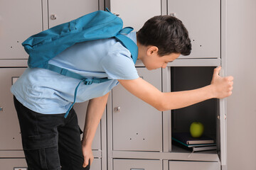 Little boy opening his locker at school