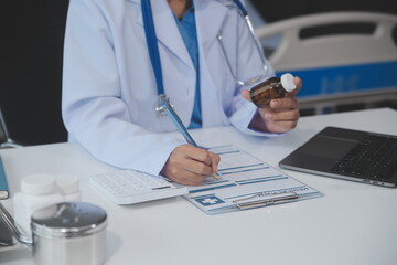 Cropped view of doctor in white coat holding bottle medication, prescribing pills to sick patient via online consultation. Family therapist recommend quality medicines. Healthcare, treatment concept