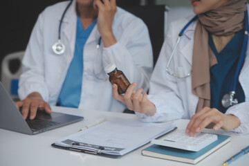 Asian psychologist women pointing on pills bottle to explaining medicine and prescription to female patient while giving counseling about medical and mental health therapy to female patient in clinic.