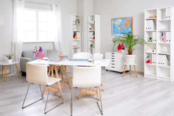 Interior of travel agency with table and different flags