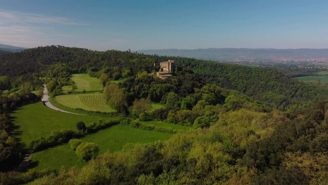 The ancient salvassola vic castle surrounded by lush forests and fields near barcelona, aerial view