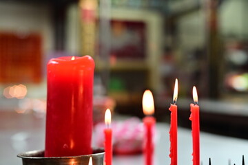 Red candles in Taiwanese temples signify worshippers' respect and requests to deities, embodying...