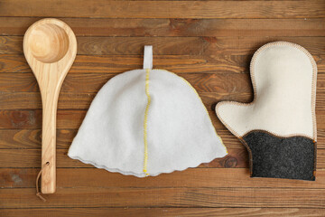 Felt hat, glove and ladle for sauna on wooden background