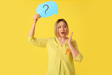 Shocked mature woman with ribbon and speech bubble on yellow background. Multiple Sclerosis...