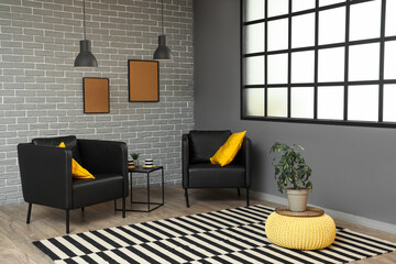 Interior of modern living room with black armchairs, table and frames