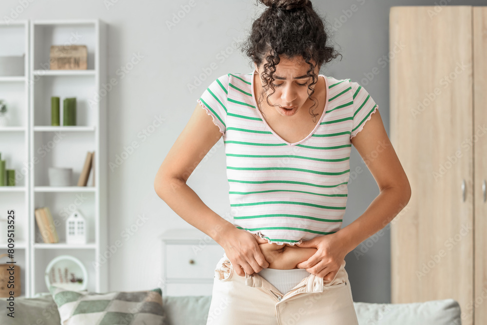 Canvas Prints Young African-American woman in tight pants at home. Diet concept