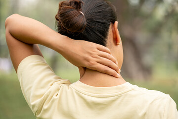 Women have neck pain, shoulder pain, at the park health concept.	