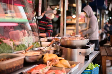 TW-01.22.24: Immerse yourself in the culinary symphony of a Dadaocheng Cisheng Temple food stall, where fresh ingredients, bustling preparation, and eager customers create a captivating spectacle.