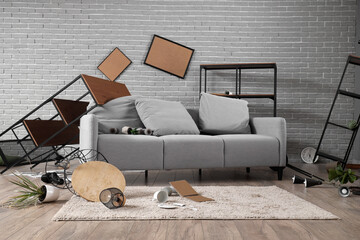 Interior of messy living room with sofa and shelf units