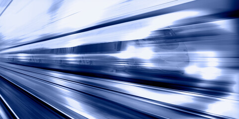 Blue high speed train runs on rail tracks - The train is going too fast as a result the air...
