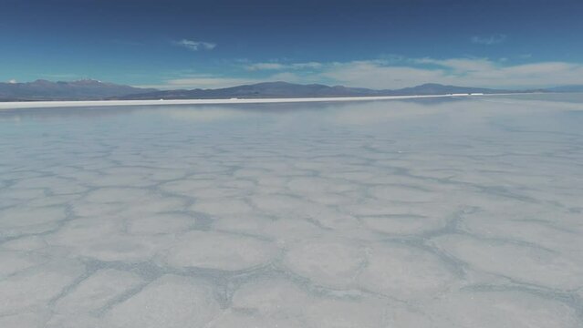 Drone shot flying over the water of the Salinas Grandes salt flat in Jujuy, Argentina. 4k
