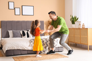 Father and his daughter dancing in bedroom. Father's Day celebration