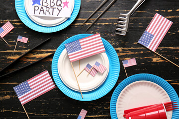 Composition with dinnerware, USA flags and barbecue utensils for Independence Day celebration on...