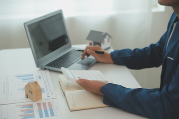 Businessmen holding pens, signing home titles with insurance, care about real estate services and the idea of real estate agents offering interest in installments to their customers.