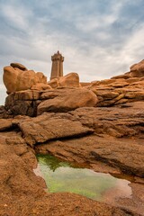 Lighthouse of Ploumanach at the golden hour in Perros-Guirec, C&ocirc;tes d'Armor, Brittany, France. Sea tide, waves, lighthouse in the background. Discover the beauty of the Brittany coast