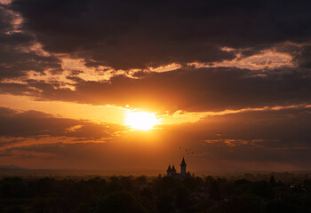 Orthodox church in sunset light. Amazing aerial view during sunset over a landmark orthodox church in Moldova region from Romania. Church and Christian cross silhouette religion.