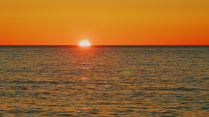 Ocean At Sunset. Right Burning Sunset Above Sea. Sun Is Setting Over Sea Or Ocean. Slow motion.