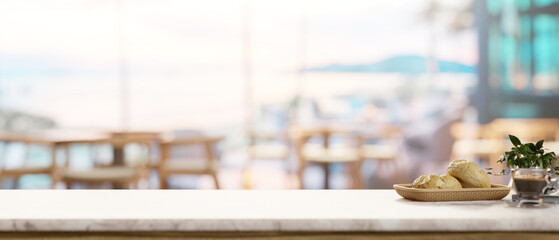 A space on a white marble tabletop, with a blurred background featuring a contemporary coffee shop.