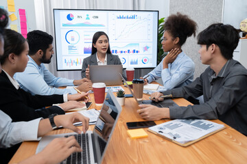 Multiracial analyst team use BI dashboard data to analyze financial report on meeting table. Group...