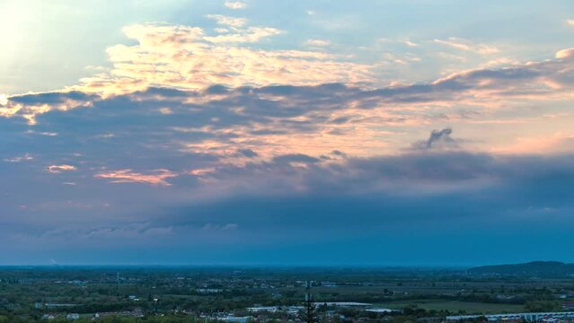 breve e rapido timelapse con inquadratura dettagliata di un'area di pianura nel nord est Italia mentre il sole tramonta dietro le nuvole e crea sfumature di arancione