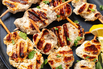 grilled mini pork skewers on a plate, top view
