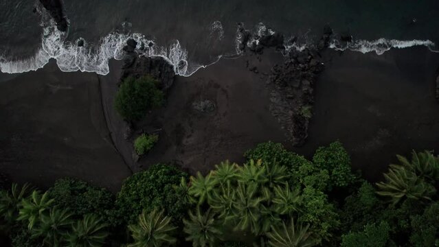 Waves arriving in a idyllic beach with dark sand