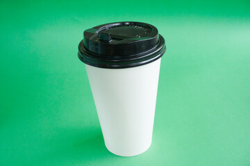 Coffee paper cup isolated on light green background.