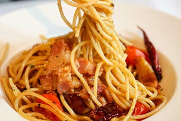 Appetizing spaghetti rolled on fork with typical Italian sauce