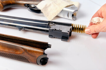 gentle cleaning of a hunting rifle using a special natural bristle brush - obrazy, fototapety, plakaty