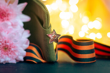 Soviet cap, St. George's ribbon on a background of flowers and glowing lights, symbols of the...