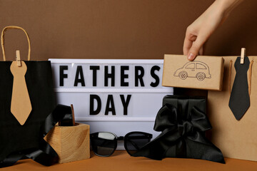 Inscription on a white chalkboard father's day, on a brown background, with gifts.