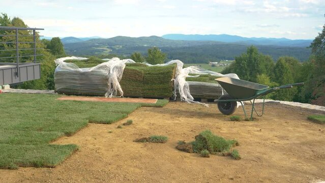 The yard of a house in the countryside gets renovated with patches of grass. 