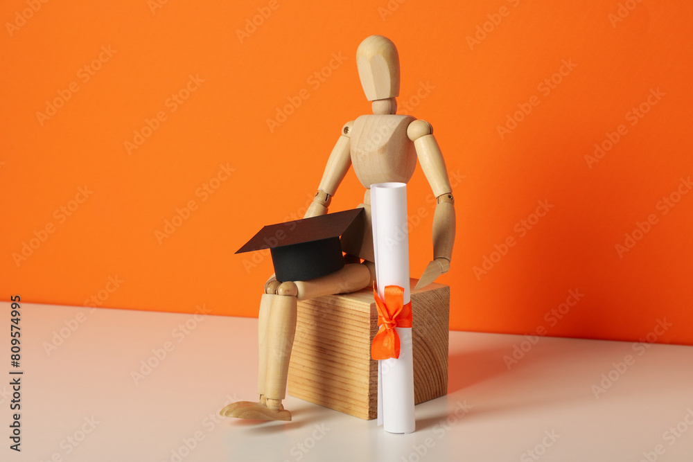 Wall mural Wooden statuette of a man with a graduation hat and diploma. - Wall murals