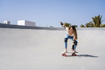 Young Woman Surfskating Down Skateboard Ramp