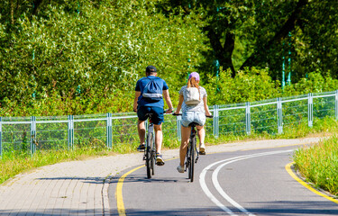 Cyclists ride on the bike path in the city Park