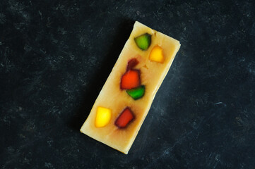 Turron fruit whole piece on a black and blue background. Traditional oriental sweet. View from a high angle. Place for text