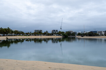The calm water at Cotton Tree. Reflection of buildings in the water on a cloudy morning. 