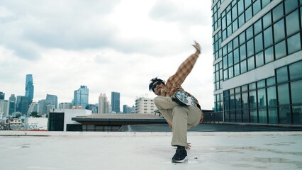 Happy hispanic dancer wears casual outfit break dancing at urban city. Energetic hip-hop...