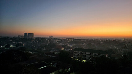 Fototapeta premium Captivating urban sunset panorama showcasing a gradient of orange hues over the city skyline