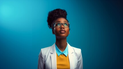 African American businesswoman in glasses, a white blazer and a yellow blouse, looking up on a blue background, copy space banner mockup