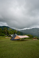 A camping tent on mountain with cloudy morning background.